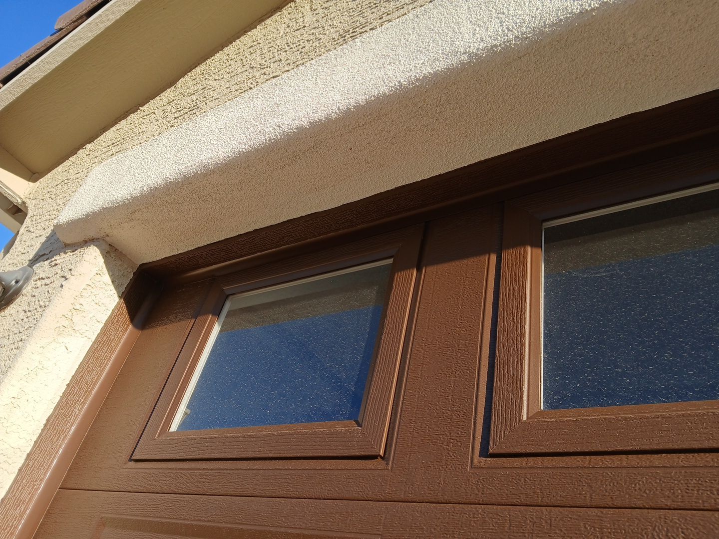 Close-up of finished eave, fascia, and garage door trim in Goodyear