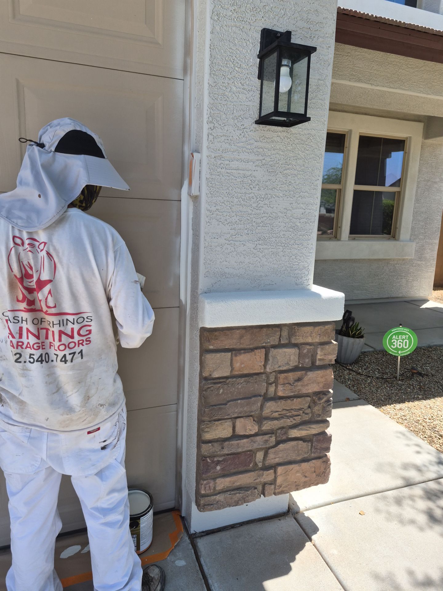 Crash of Rhinos employee painting a garage door jamb in Sun City