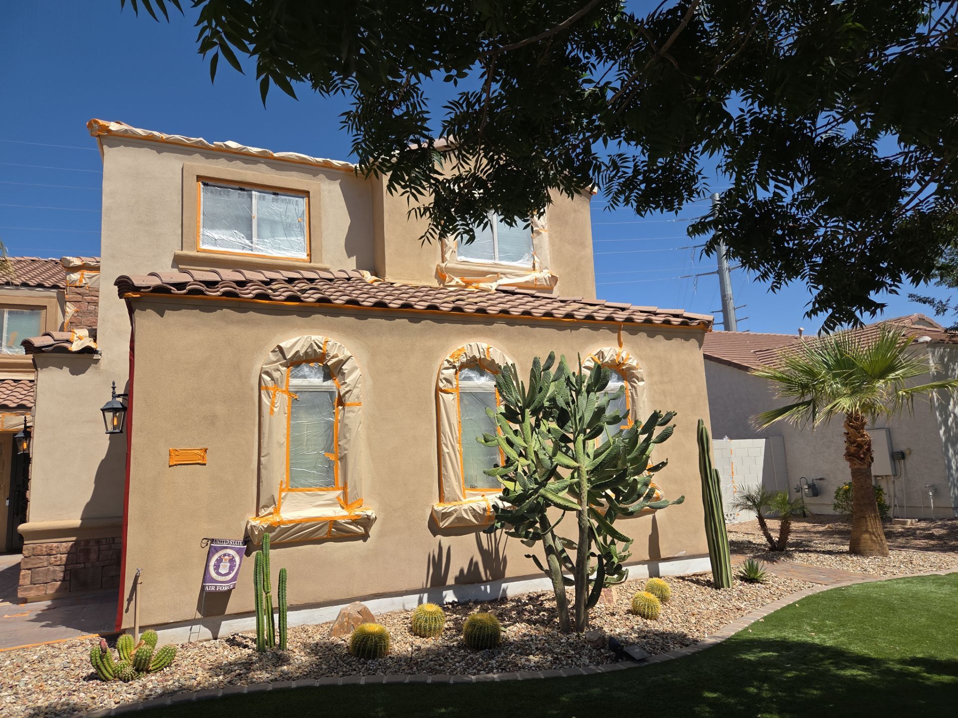 Masked windows and roofline on a Queen Creek home during painting