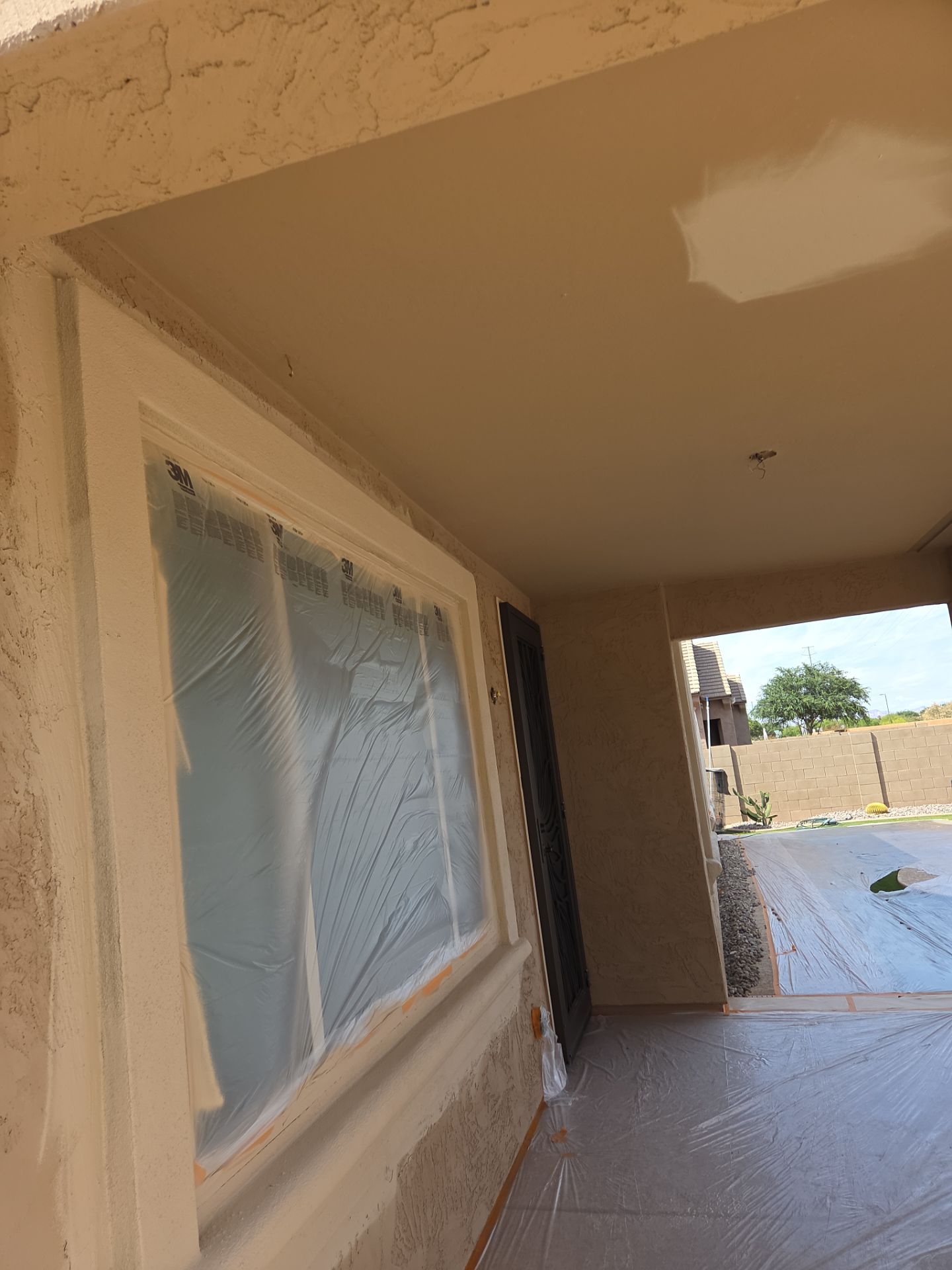 Masked patio window and freshly coated ceiling on a Queen Creek home