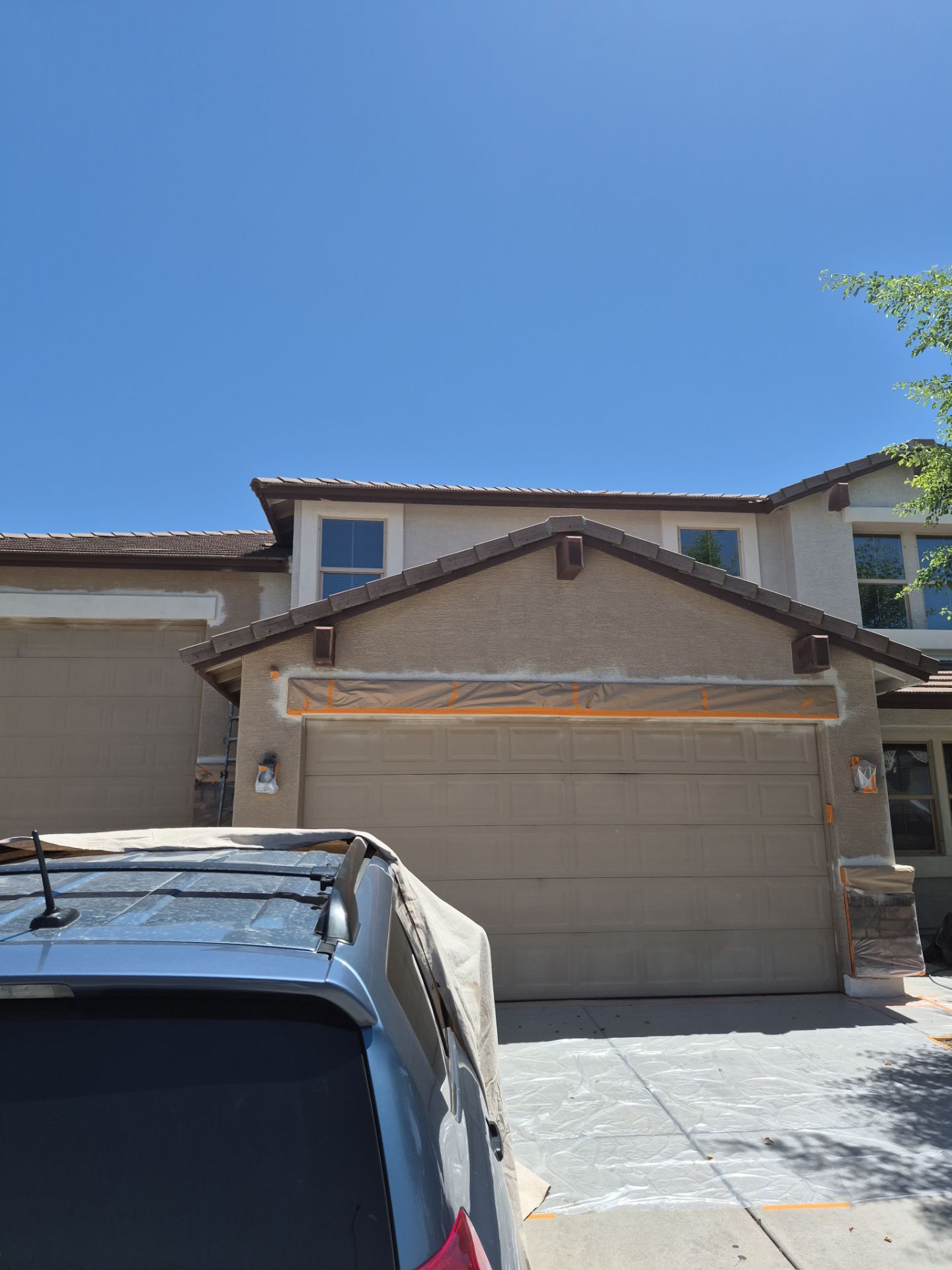 Masked garage and gable on a Sun City home mid repaint
