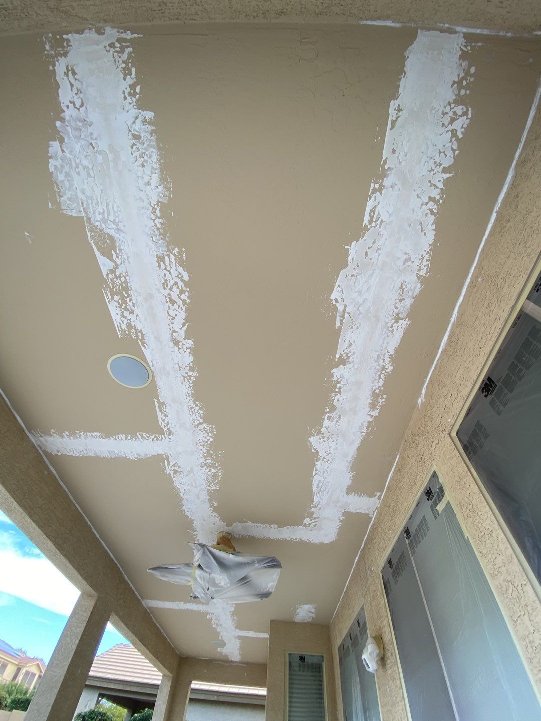 Patched porch ceiling on a Surprise home before the color coat