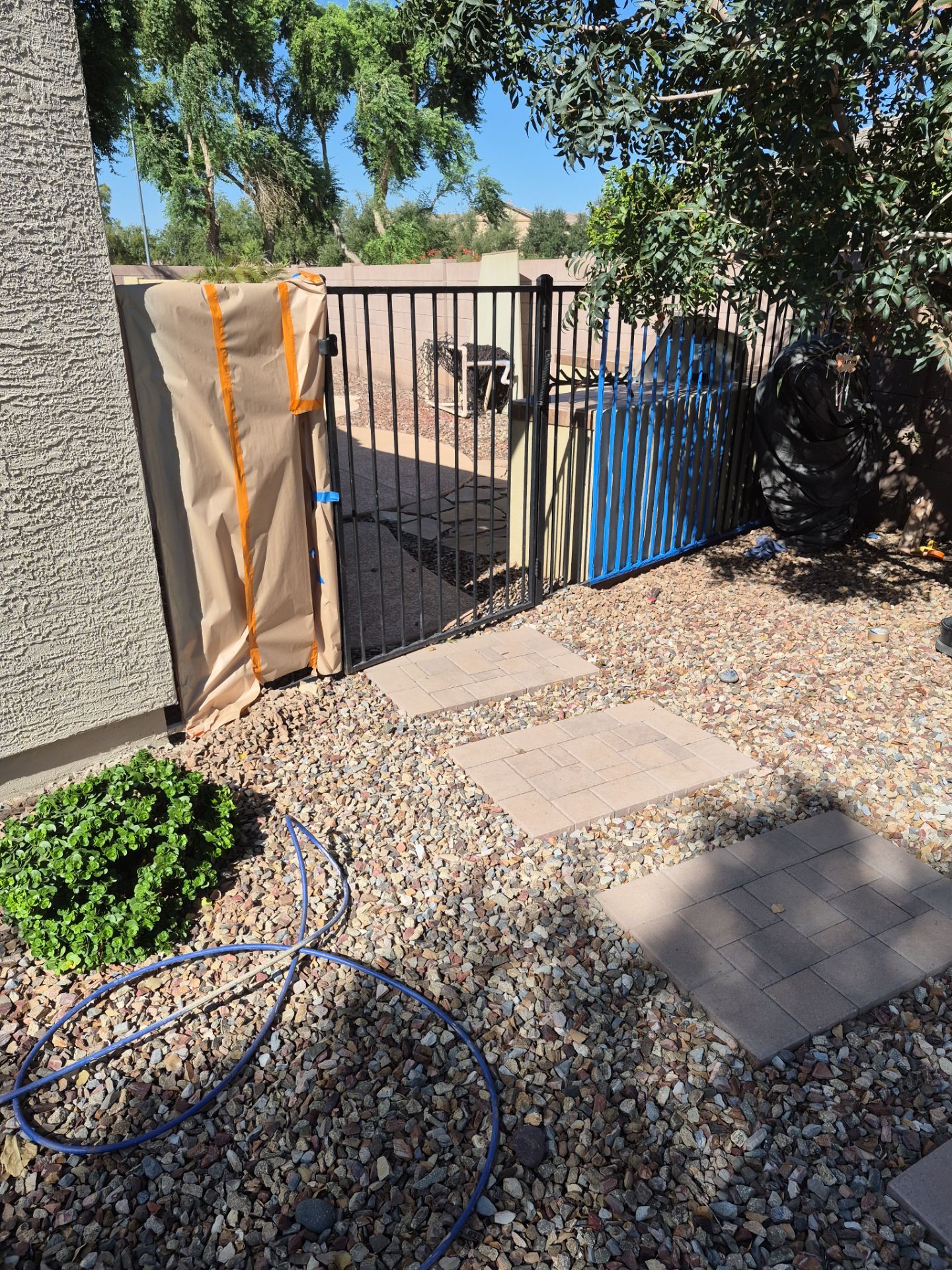 Masked gate and fencing at a Chandler home during painting