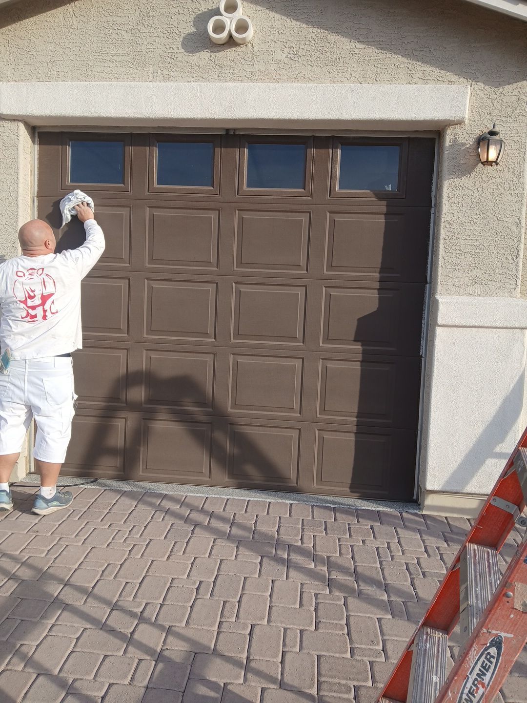 Crash of Rhinos employee wiping down a freshly coated Goodyear garage door