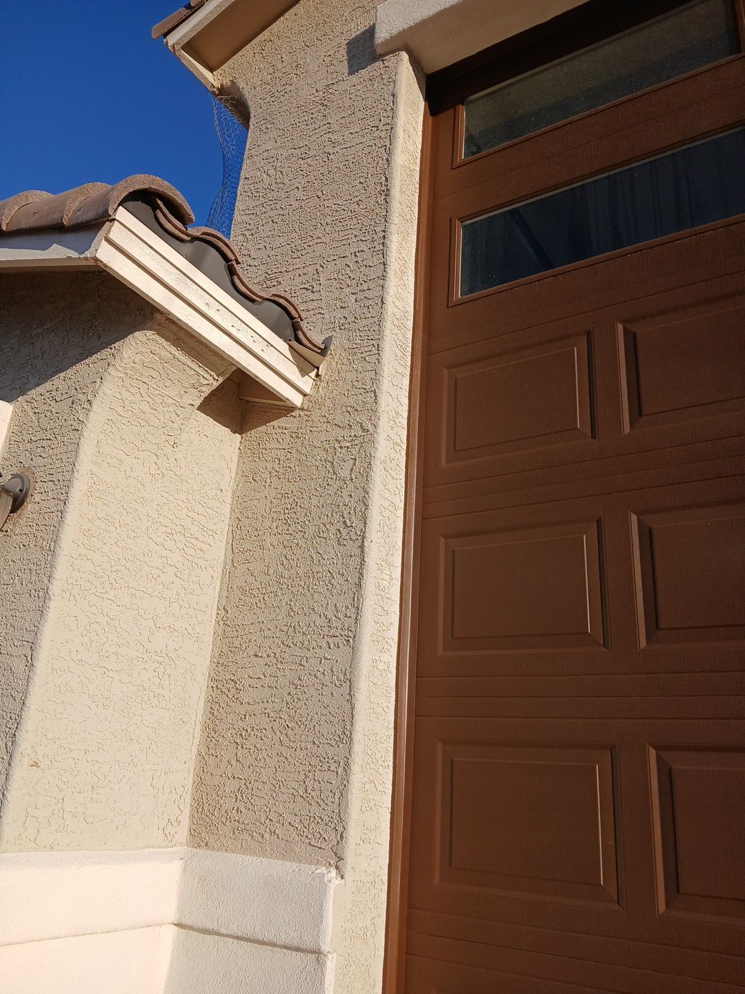Finished stucco pop-outs beside a repainted garage door in Goodyear