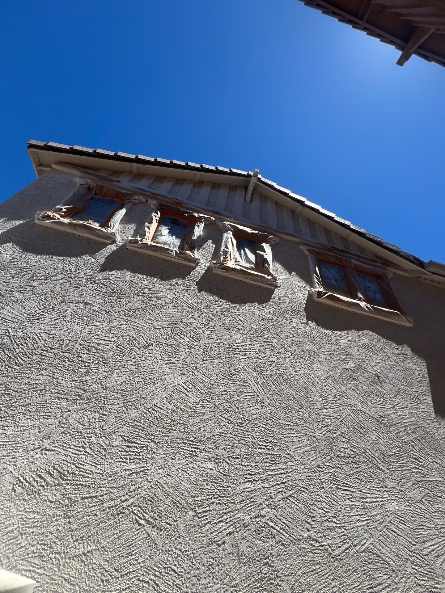 Freshly painted upper wall and eaves on a Gilbert two-story home