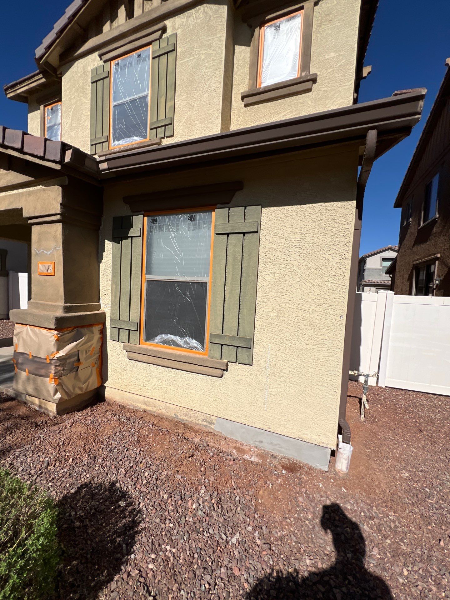 Masked windows and shutters on a Gilbert home before painting