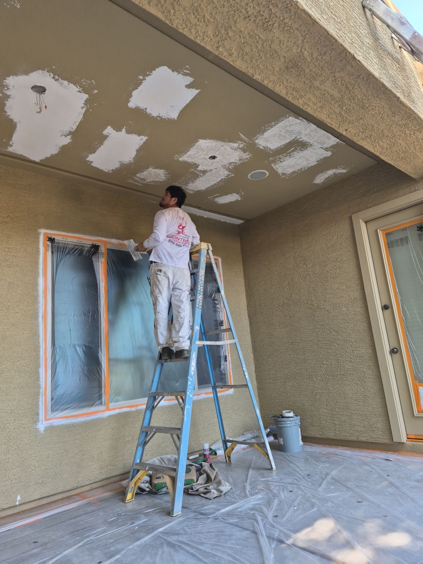 Crash of Rhinos employee patching a Chandler patio ceiling before painting