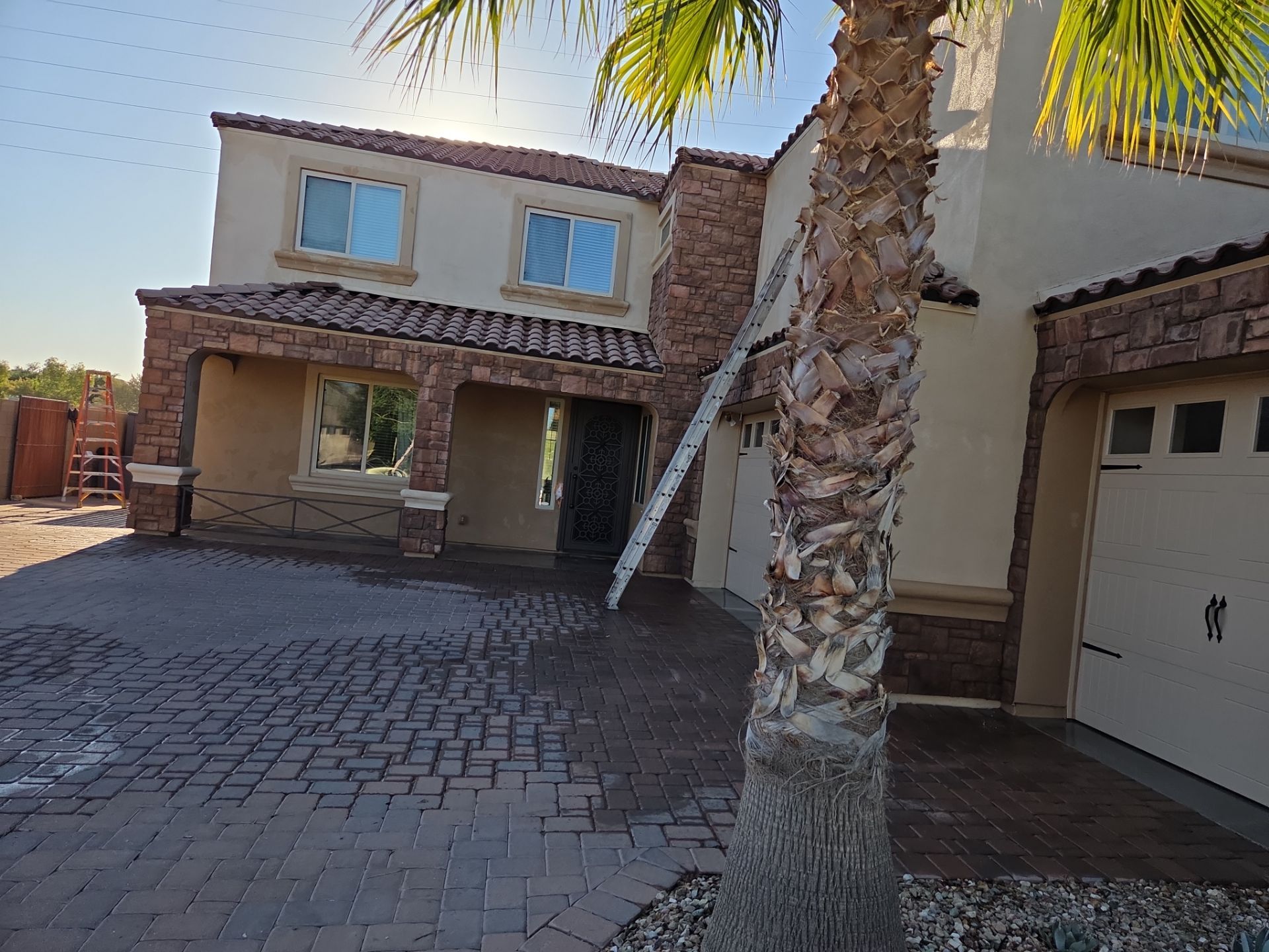 Ladder set against a Queen Creek home mid repaint