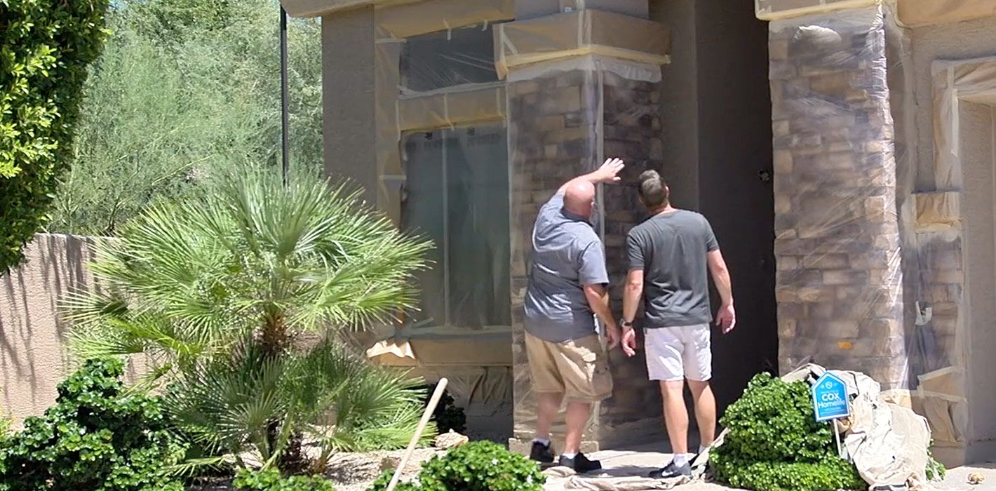 A member of our team reviews our prep work and protective sheeting with a local homeowner ahead of the painting phase.
