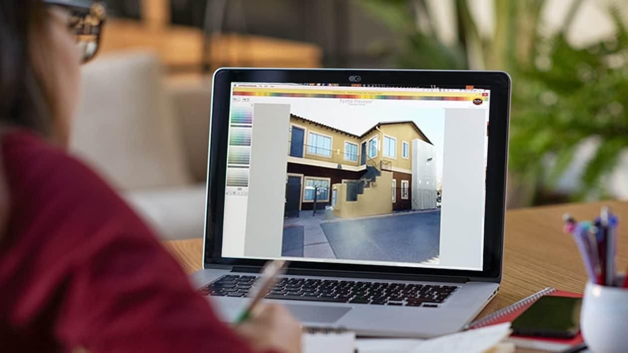 A house rendering shown on a laptop screen