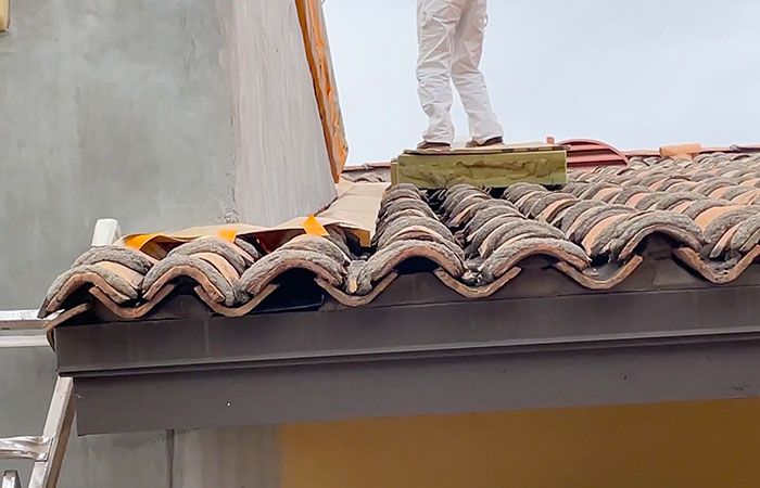 Masking house with clay roof tiles to prep for paint