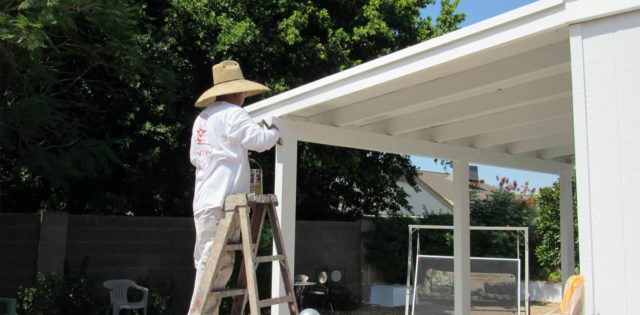 Our painter hand-brushes paint onto this patio cover, ensuring that the paint fully adheres to the surface.
