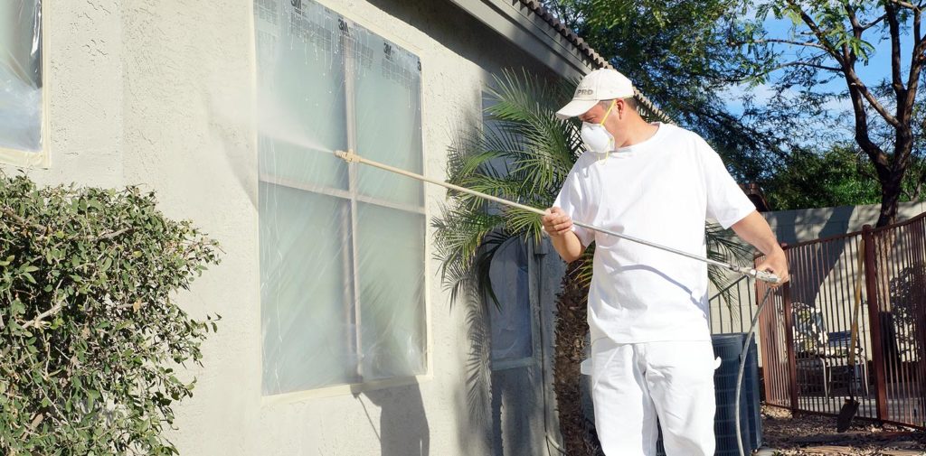 With the windows masked and taped, our painter begins the paint application process using professional-grade painting tools.