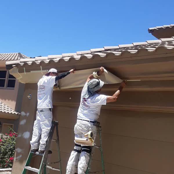With this Glendale home completely painted, two of our painters carefully remove the masking and tape protecting the accent trim.