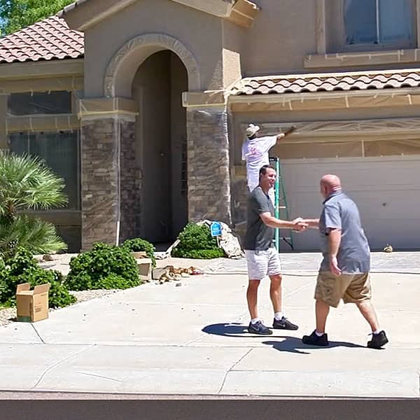 Our owner, Mike Ricker, shakes the hand of a local homeowner and updates them on the state of their current painting project.