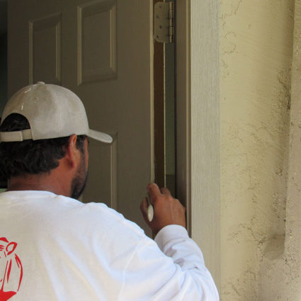 Using a brush, our painter adds the finishing touches to a front door here in Gilbert, AZ.