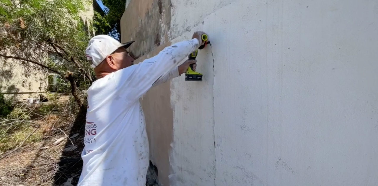 grinding-old-stucco-on-a-retaining-wall